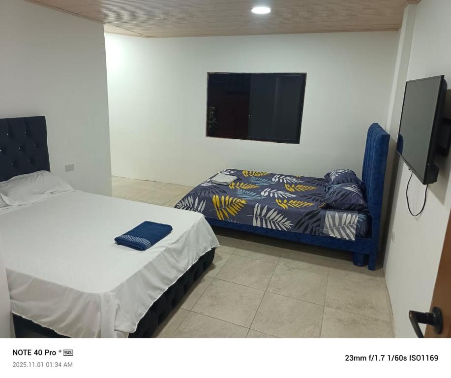 a small bedroom with a bed and a tv at Hospedaje Búho's E in Guayaquil