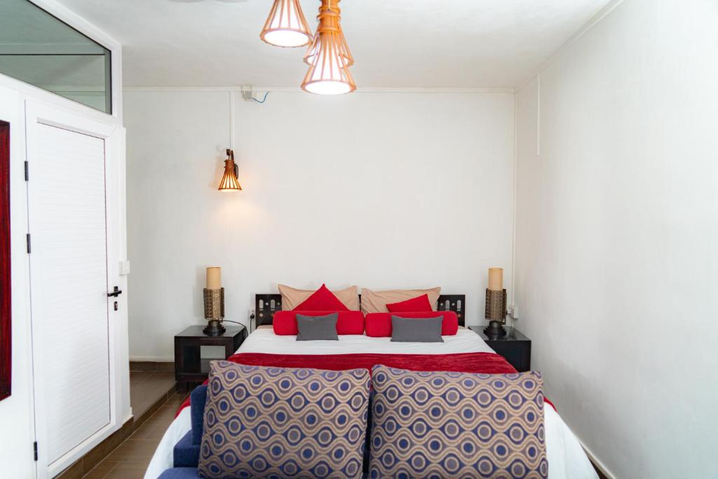 a bedroom with a large bed with red pillows at Ahavah Guesthouse in Trou dʼ Eau Douce