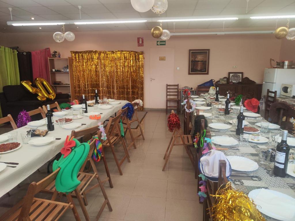 een kamer met lange tafels en stoelen met eten erop bij Goizeder Casa Completa 8 habitaciones & Txoko 100 m in Espinal-Auzperri