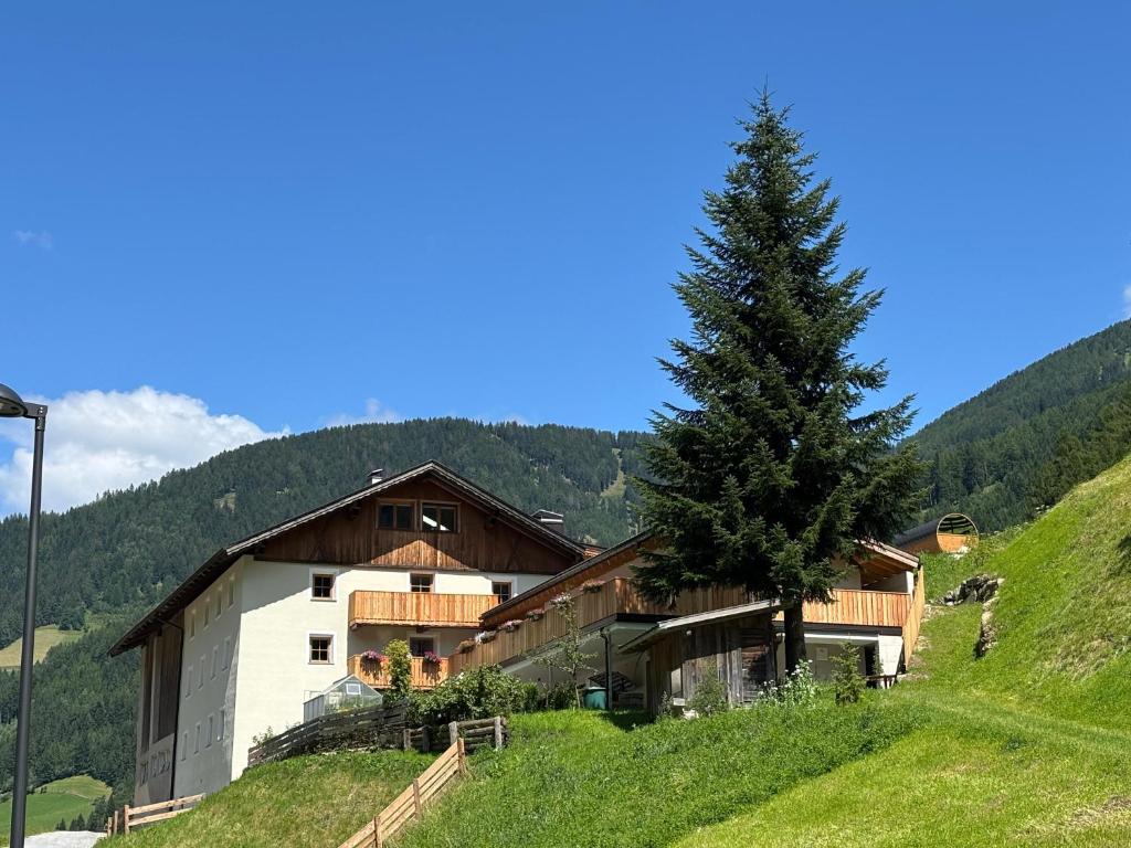 a building on a hill with a tree on it at Hanselerhof Jaufental Ratschings mit Sauna in Racines