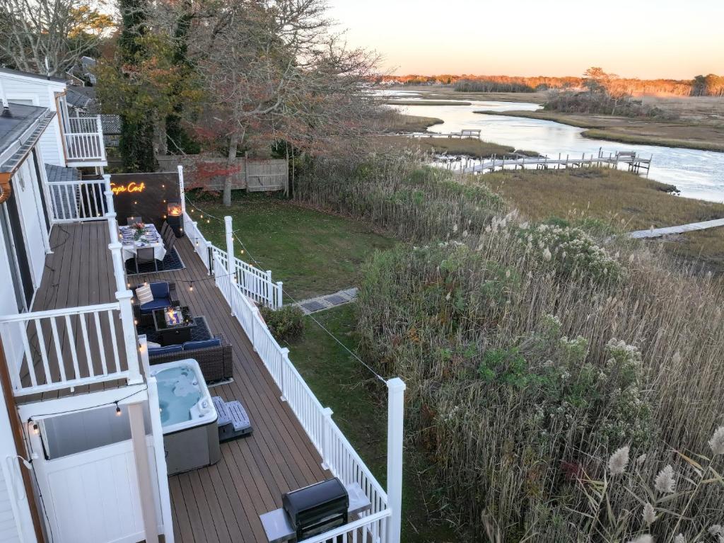 a house with a deck with a view of a river at Waterfront Escape HotTub, Pets OK, Pool Table in Dennis