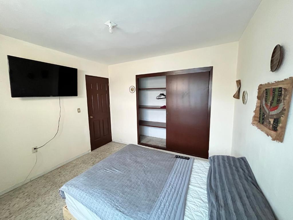 a bedroom with a bed and a flat screen tv at Casona el Sol in Veracruz