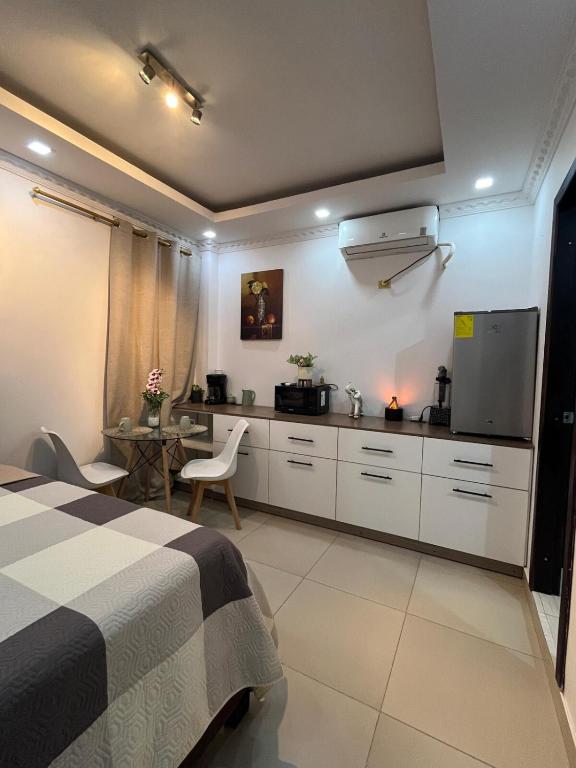 a bedroom with a bed and a desk and a kitchen at Habitación en la ciudad de Francisco de Orellana in Francisco de Orellana