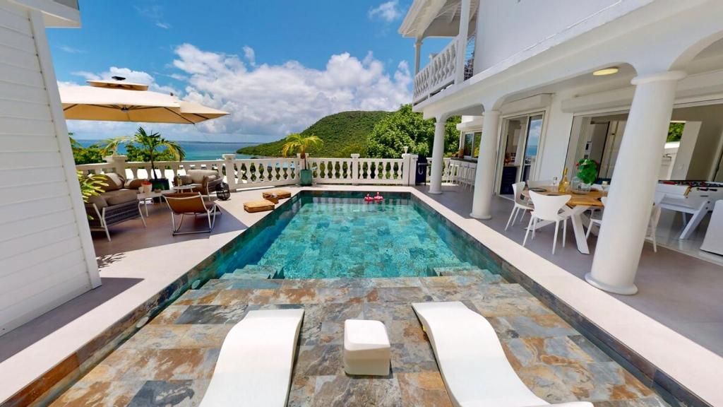 a swimming pool in the middle of a house at Villa Princess sea view private pool Anse Marcel in Saint Martin