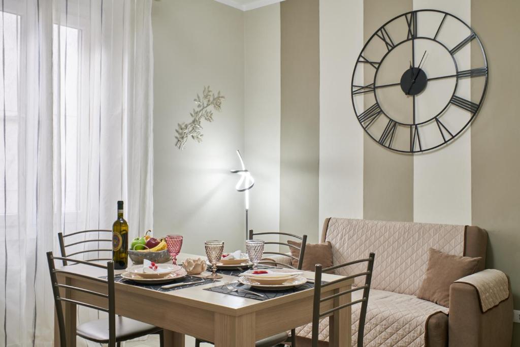 een eetkamer met een tafel en een klok aan de muur bij Cristina Tuscany Holiday in Poggibonsi
