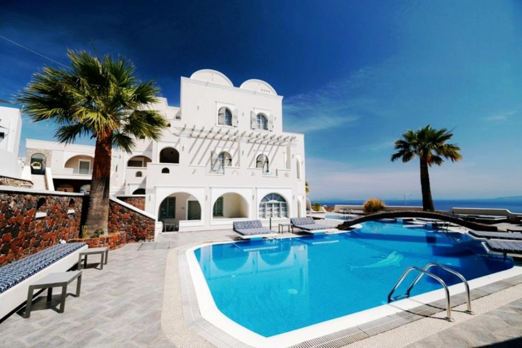 a villa with a swimming pool in front of a building at my life suites in Fira