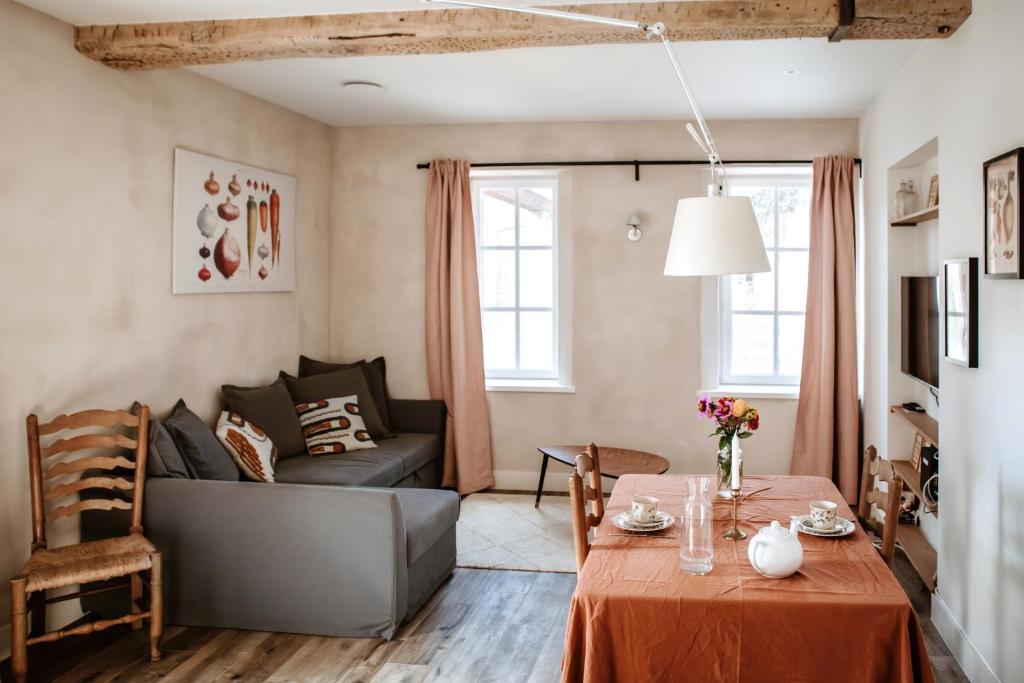 een woonkamer met een tafel en een bank bij Gîte de la maraîchère in Ittre