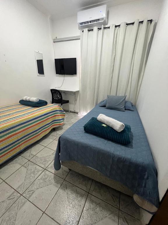 a bedroom with two beds and a desk at Cantinho aconchegante - Quarto 09 - AR-condicionado in Bayeux