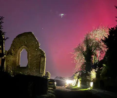 ein altes Gebäude bei Nacht mit rotem Himmel in der Unterkunft Luxury Studio Nestled in the Sussex Countryside in Battle