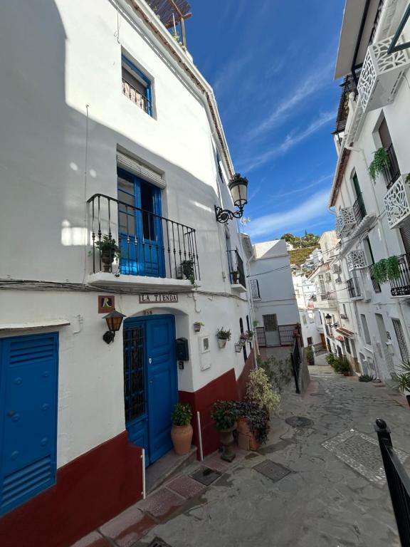 een straat met twee gebouwen met blauwe deuren bij Guesthouse La Tienda Cómpeta 21b in Cómpeta