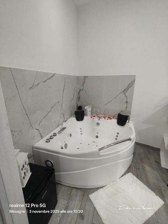 a white bath tub in a bathroom with marble walls at CarpeDiemHouse in Mesagne