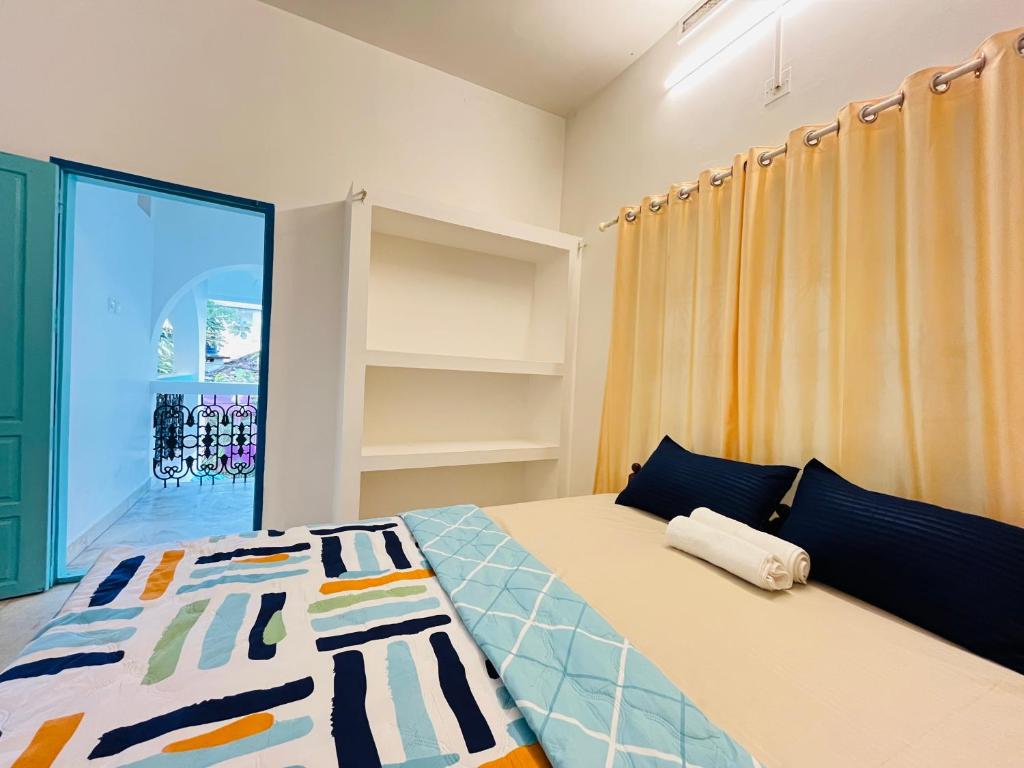 a bedroom with a bed and a large window at Lima Beach House Varkala in Varkala