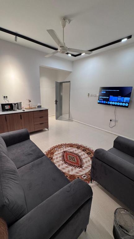 a living room with a couch and a flat screen tv at Aurum Azure in Nizwa