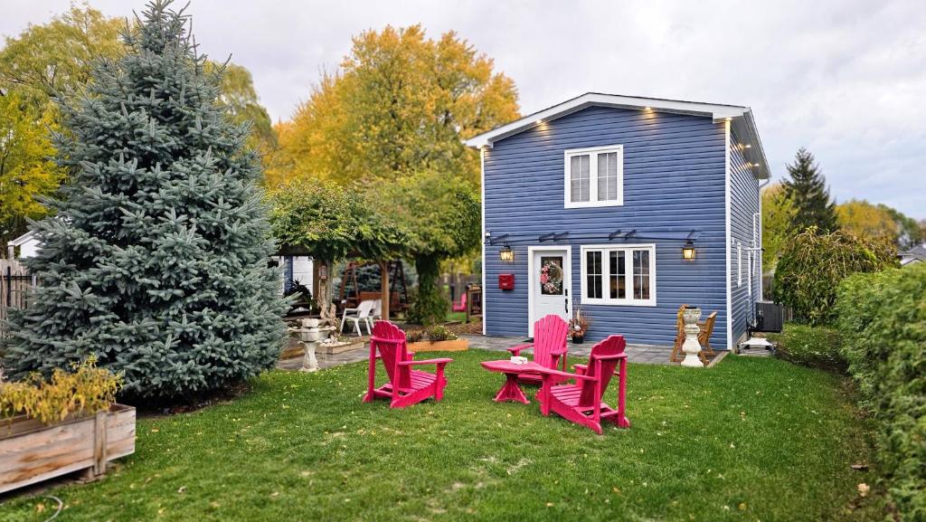 a yard with red chairs and a blue house at Luxury Family House 3 beds, 1 bath, 5 guest in Toronto