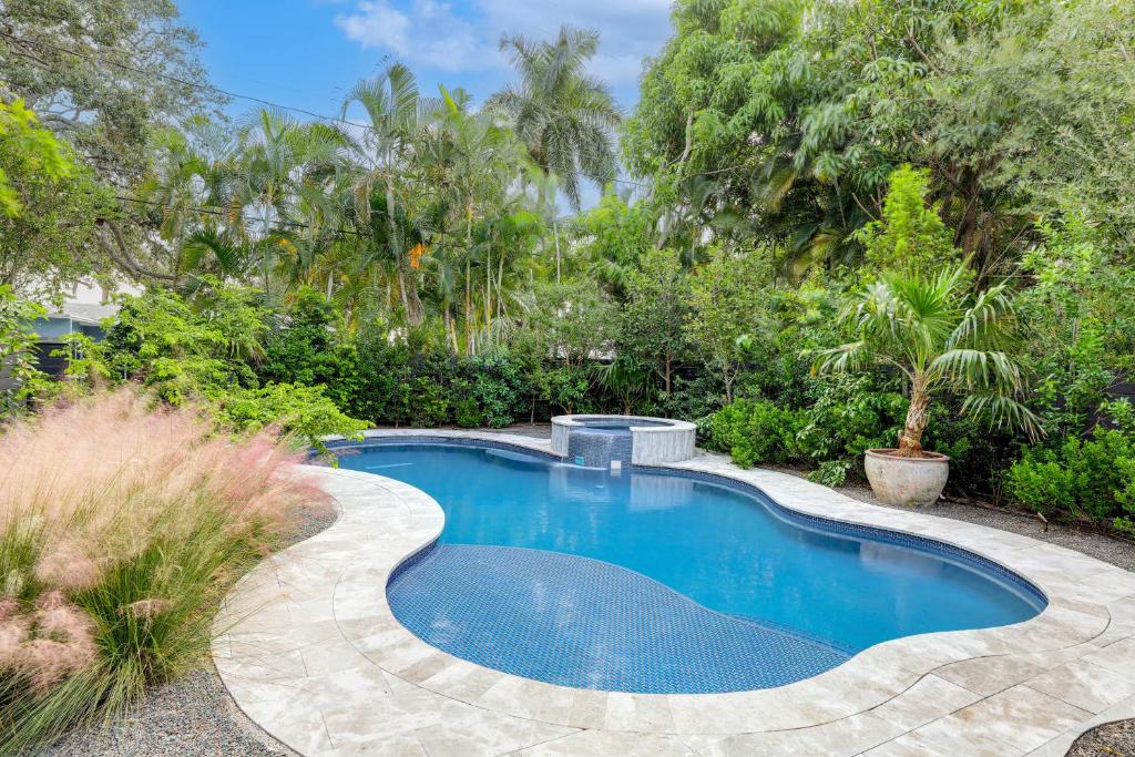 a swimming pool in a garden with trees at 1 Mi to Lake Worth Beach Park Poolside Paradise! in Lake Worth
