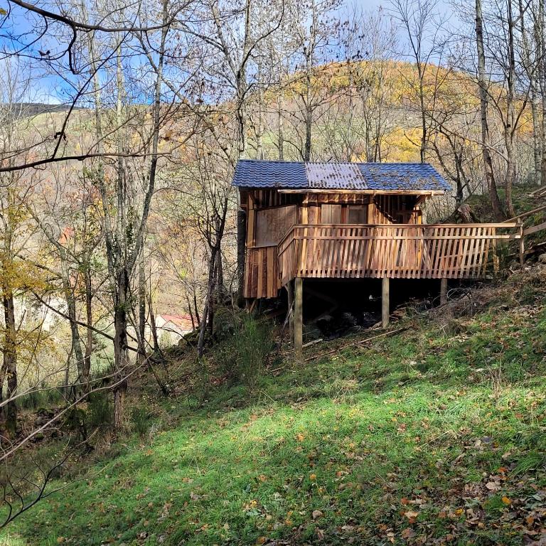 uma casa de madeira com telhado solar em uma colina em Cabane octogone sauvage - Octogonia, Ardèche em La Rochette