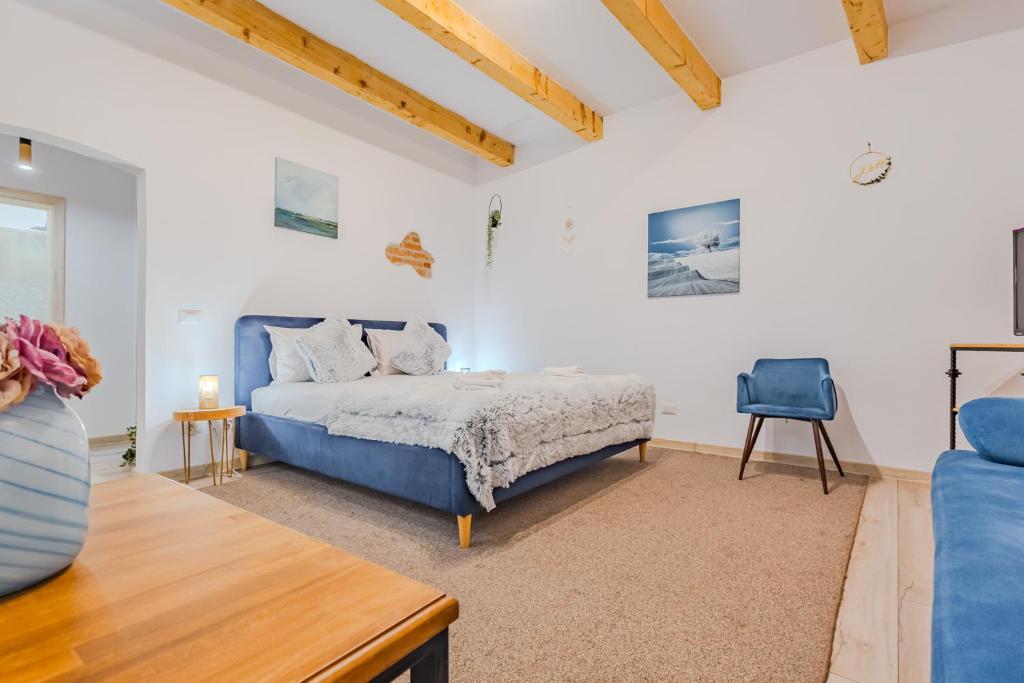 una camera con un letto blu e una sedia blu di Arctic Apartment a Braşov