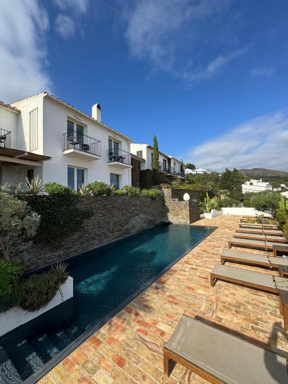 a swimming pool next to a building with a resort at Boutique Hotel Villa Gala by Fimedhotels in Cadaqués