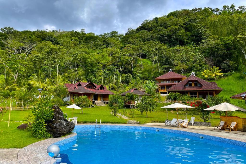 een resort met een groot zwembad en huizen bij Mercedes Lodge in San Ramón