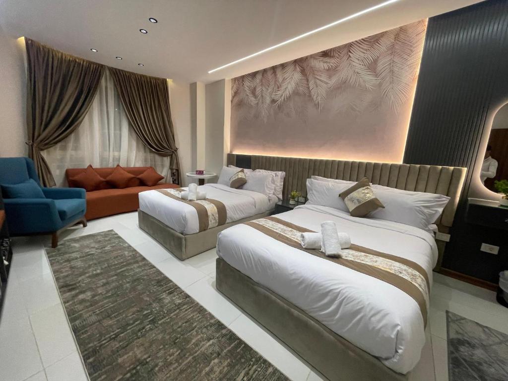 una habitación de hotel con dos camas y un sofá en Atlantis Hotel, en El Cairo