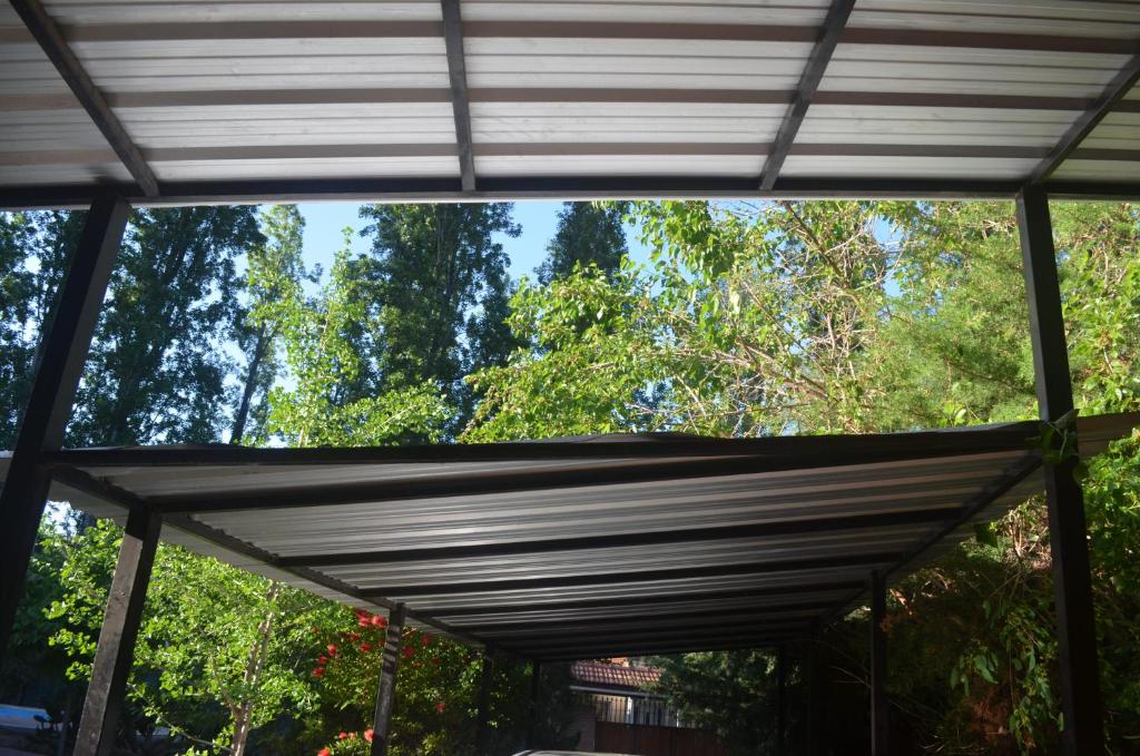 Markise über einer Terrasse mit Bäumen im Hintergrund in der Unterkunft Casa rústica en zona de bodegas amplio jardín pileta fogón y churrasqueara in Ciudad Lujan de Cuyo