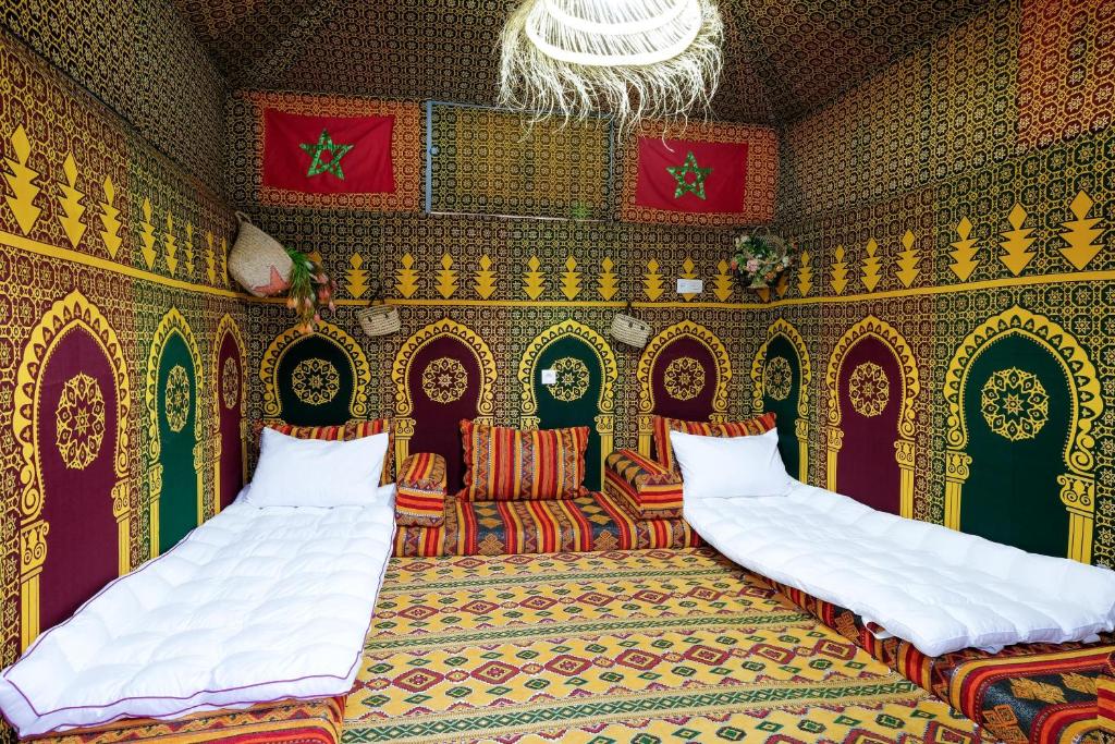 a room with two beds and a couch and a chandelier at Authentic Berber Studio in Benguerir