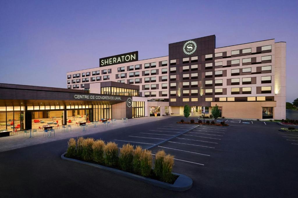 Un gran edificio con un cartel encima. en Sheraton Laval Hotel, en Laval