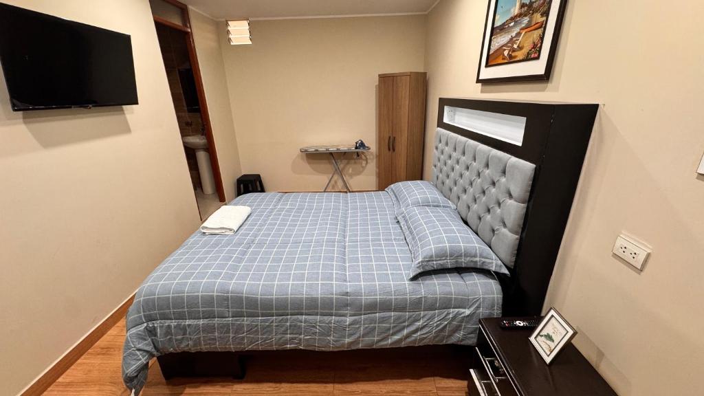 a small bedroom with a bed and a television at Apartamento VIP LEO in Tacna