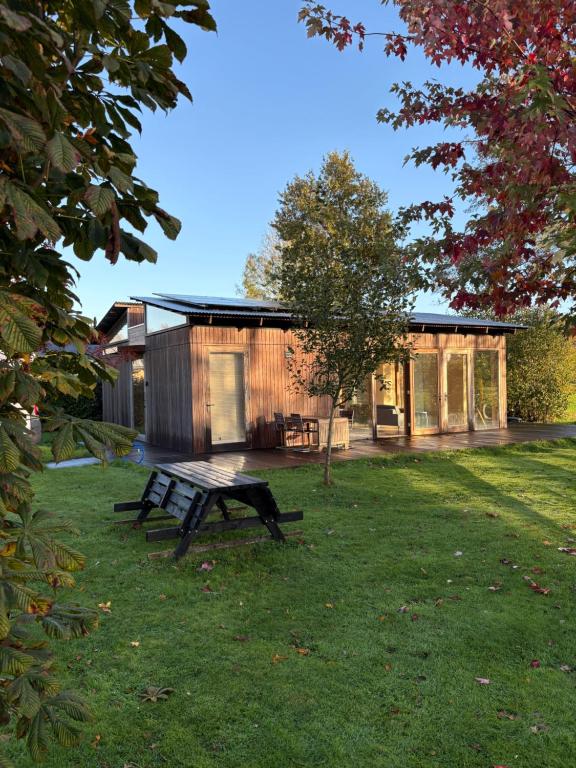 une maison en bois avec une table de pique-nique dans l'herbe dans l'établissement Bamboo House, à Boyl
