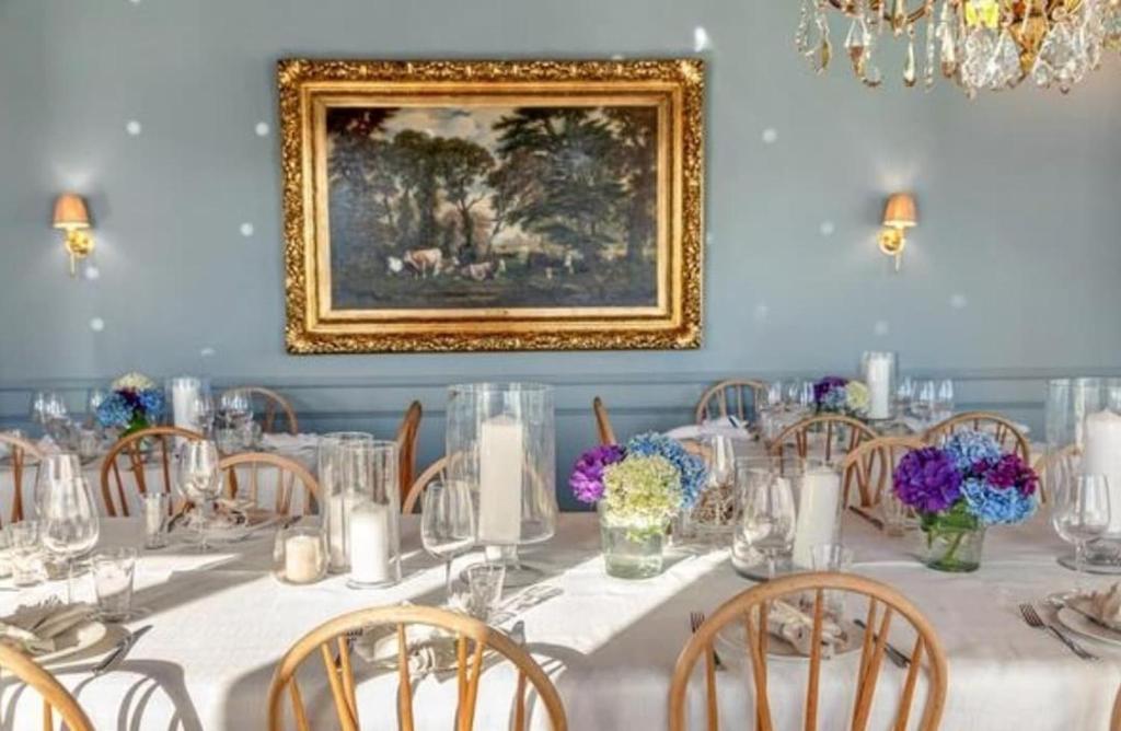 a dining room with a white table with chairs and a painting at Rent your own Boutiqe hotel in Skammestein