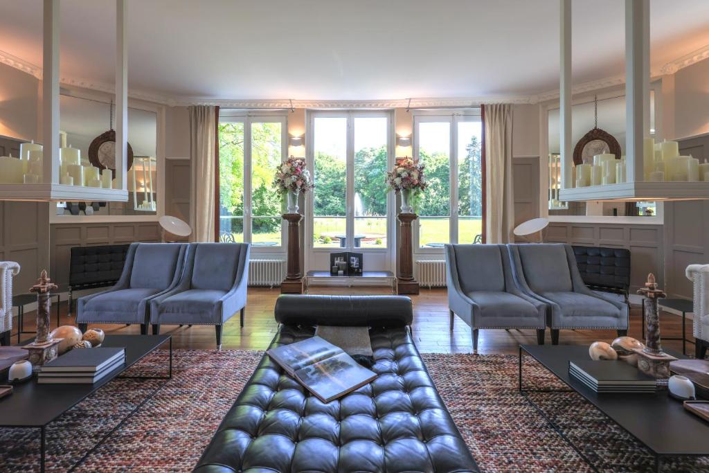a living room with blue chairs and a couch at L’orée du bois des rois in Ury