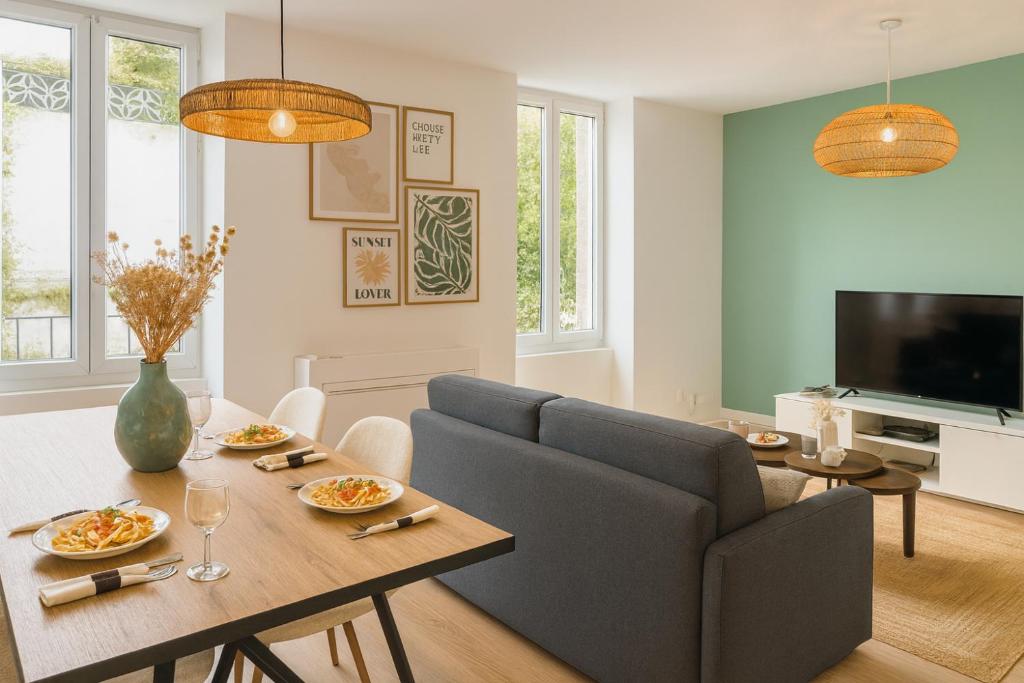 a living room with a couch and a table at THE COSY HOME Centre ville Parking Clim in Valence