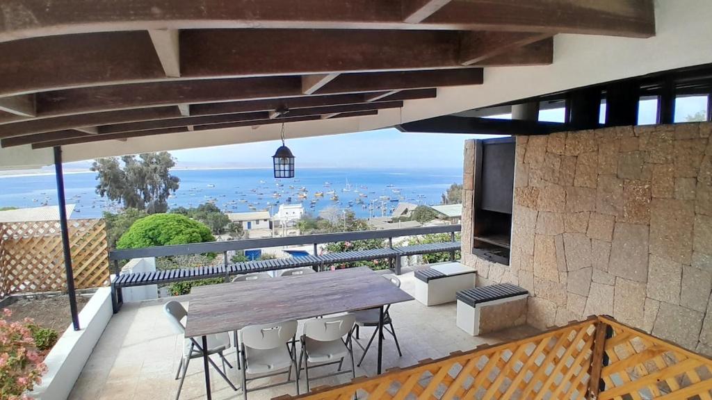 a patio with a wooden table and chairs on a balcony at Tongoy Bauhaus - Alojamiento hasta 12 personas in Tongoy