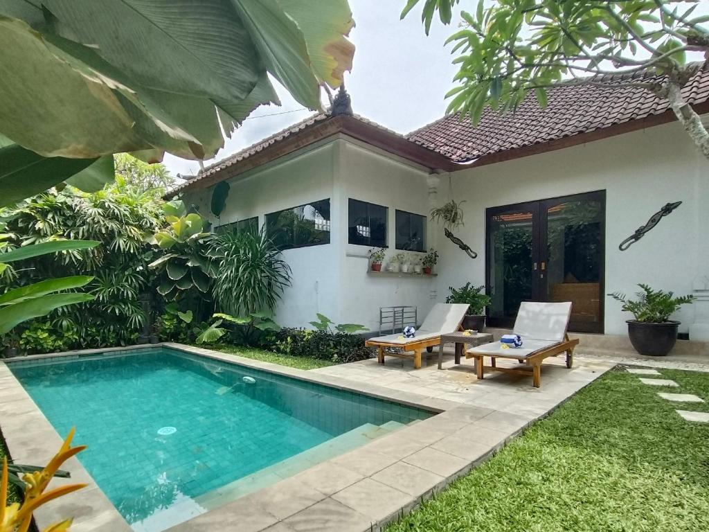 una villa con piscina frente a una casa en Villa MONTI - LEGIAN - SEMINYAK - Lovely 2 Bedroom Villa - Great Location !, en Seminyak