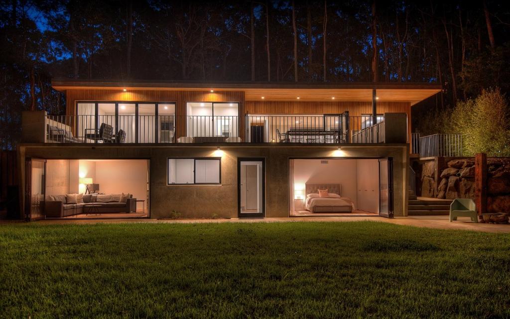 ein großes Haus bei Nacht mit eingeschaltetem Licht in der Unterkunft Daydream Cottage Beachside Luxury in Lilli Pilli in Surf Beach
