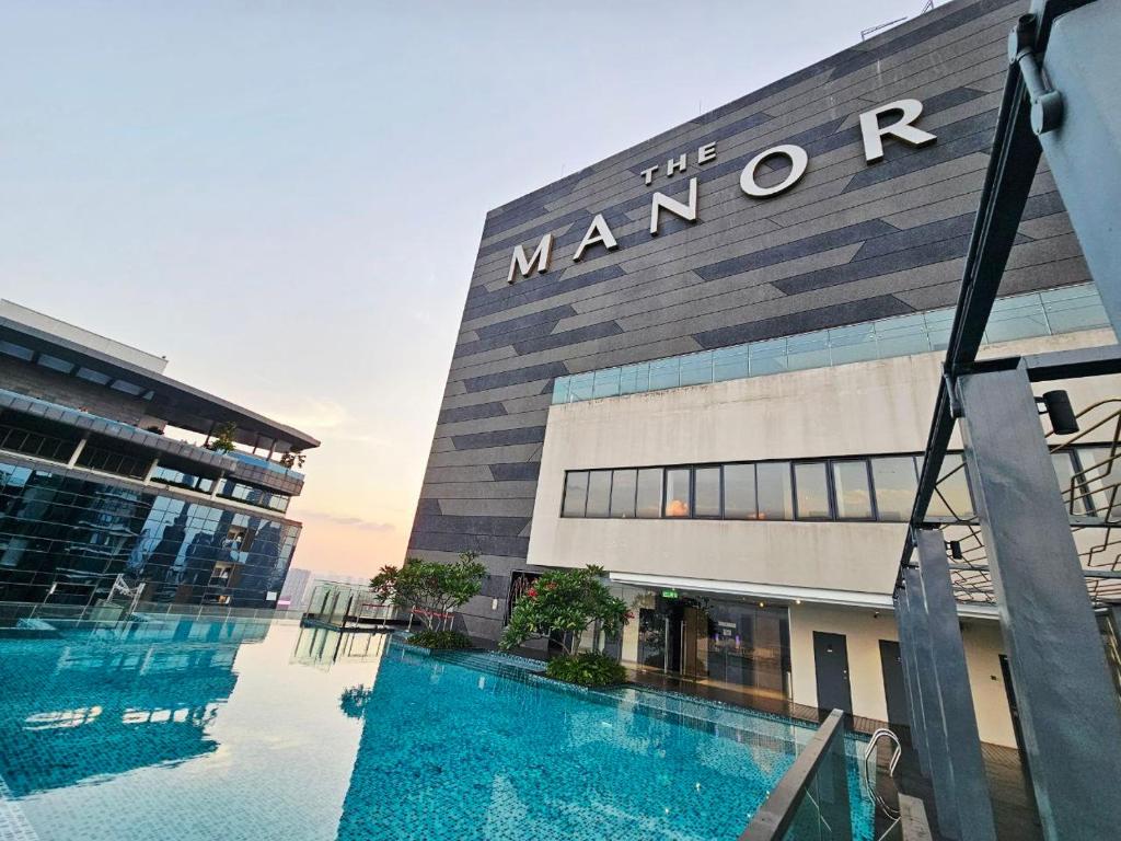 a building with a swimming pool in front of it at Panorama luxury Suites At TM Persiaran Stonor KLCC in Kuala Lumpur