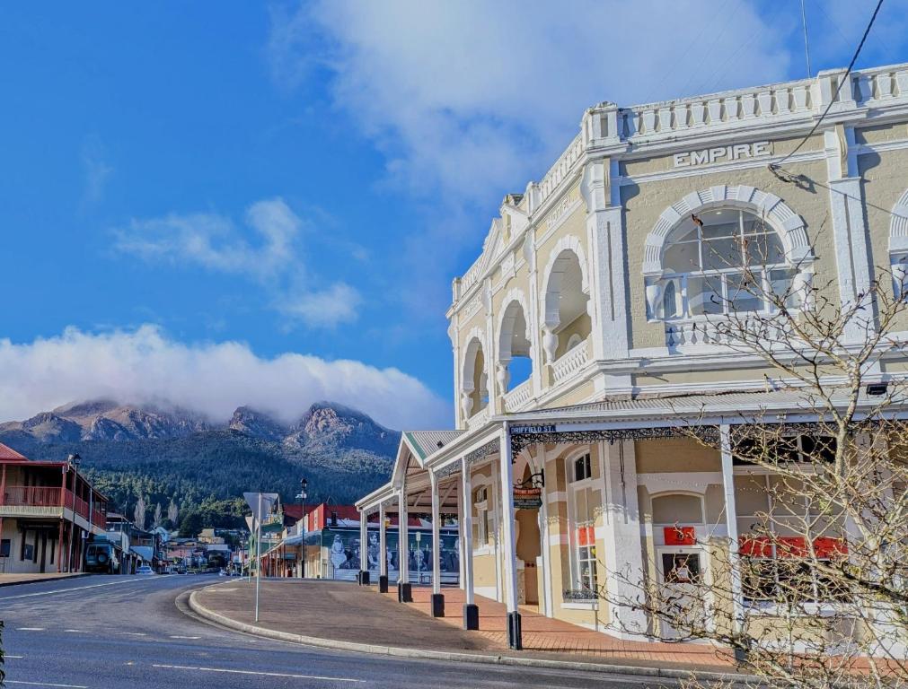 a building on a street with mountains in the background at Quentin's Cottage in Queenstown