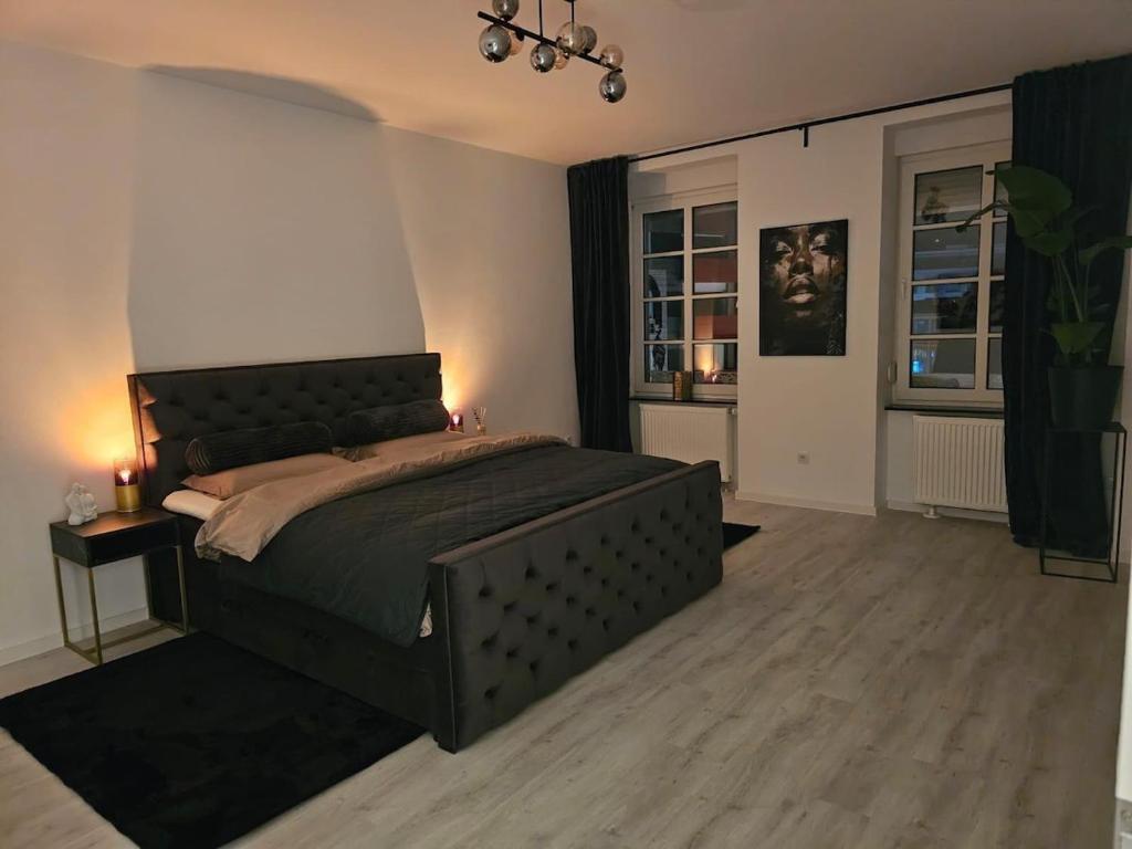ein Schlafzimmer mit einem großen Bett und zwei Fenstern in der Unterkunft Good Vibes Luxury Homes in Kaiserslautern