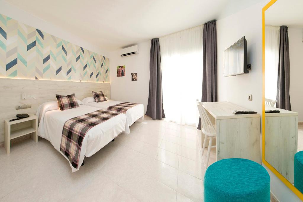 a hotel room with a bed and a desk at Hotel Vibra Lei Ibiza - Adults only in Ibiza Town