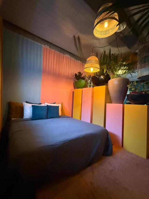 a bedroom with a bed with brightly colored walls at Plantkot, a cozy apartment full of plants of tinykot in Keerselaar