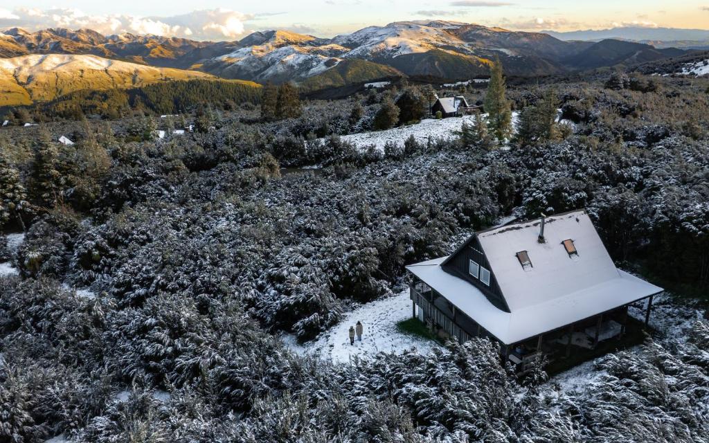 an old house in a field with snow on it at Alpine Haven, Peaceful , Stunning Views - ML21396 in Mt Lyford