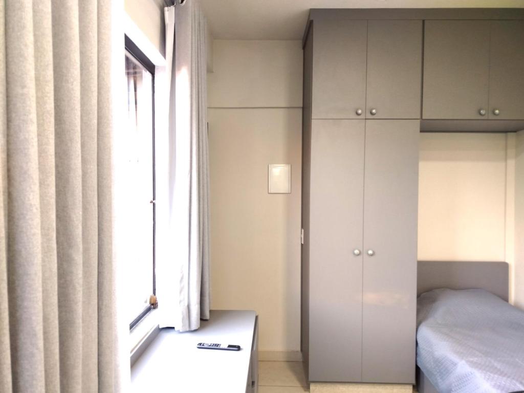 a bedroom with a bed and a window at Vila Del Rei - Flat no Centro de São João Del rei in São João del Rei