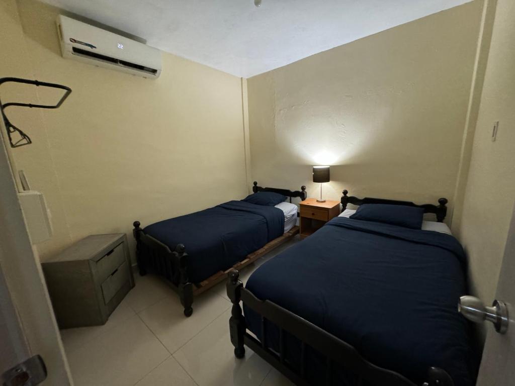 a room with two beds and a table with a lamp at Excelente apartamento para 4 personas in Monterrey