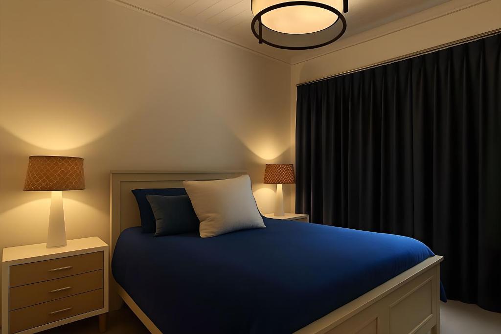 een slaapkamer met een blauw bed en een raam bij Jackson Pearl in Jackson