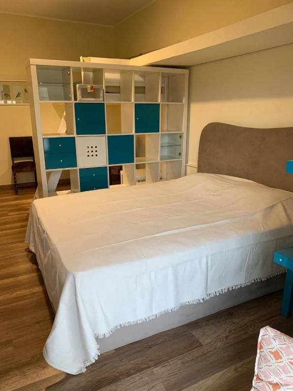 a bedroom with a large white bed with blue shelves at Kaza home hotel in Cairo