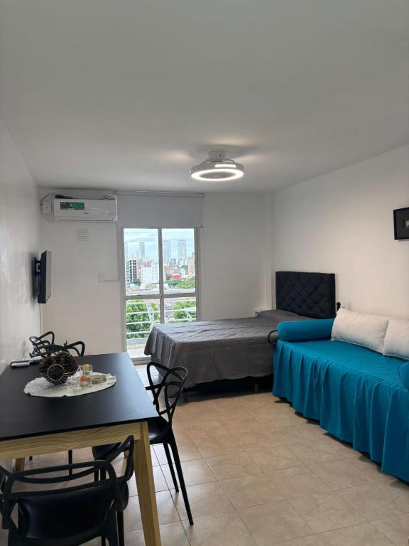 Habitación con cama, mesa, cama y mesa de comedor. en Loft - Zona hospitales - Familias!, en Rosario