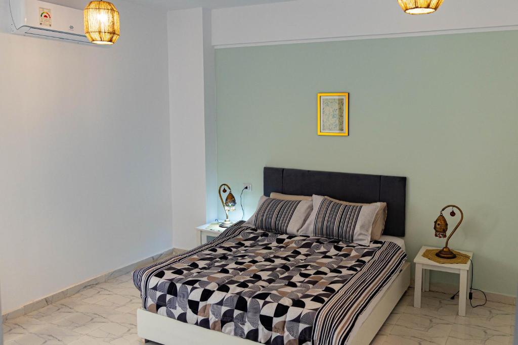 a bedroom with a bed with a black and white comforter at Christmas Arabic Escape Roof Terrace 3 Bedroom Luxury Appartment Superb Location and just 15 mins from El Gouna in Hurghada