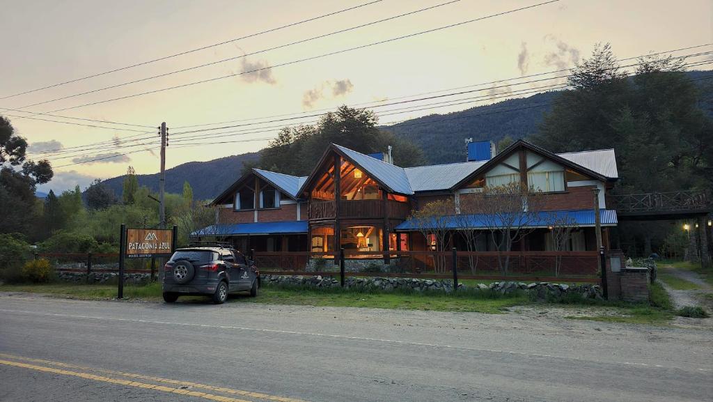 ein vor einem großen Haus geparkt in der Unterkunft Patagonia Azul Hostel Boutique in Lago Puelo