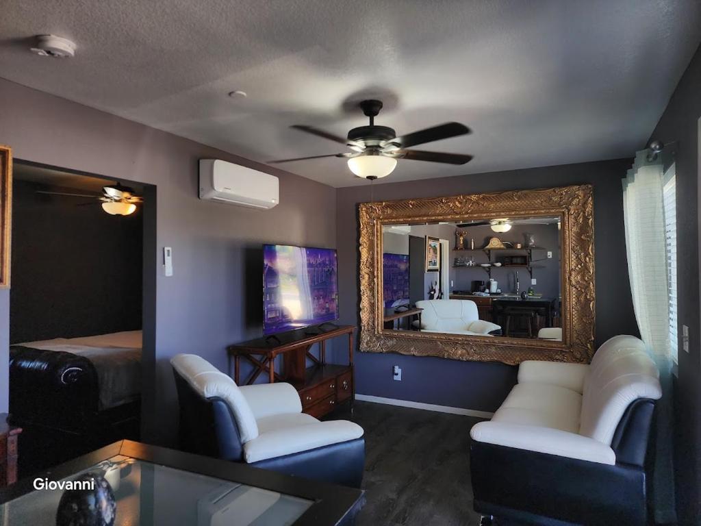 a living room with a ceiling fan and a mirror at Sunrise Springs in Pahrump