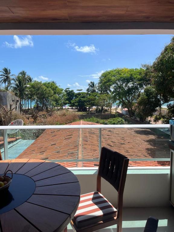 a balcony with a table and a view of the ocean at Flat in Tamandaré